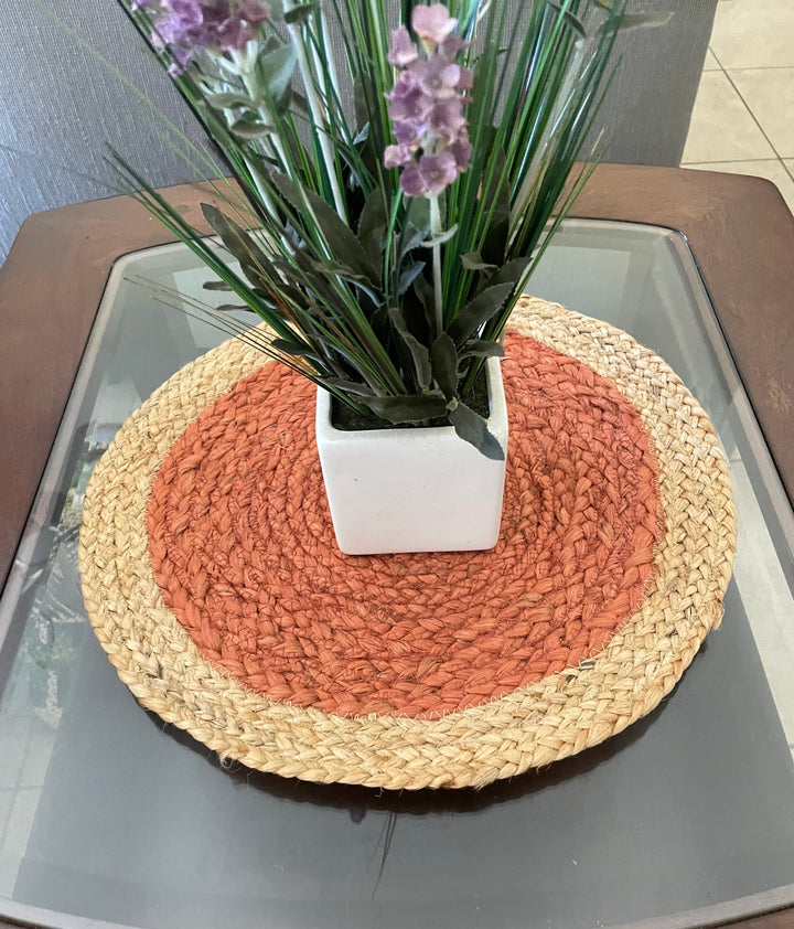 Set of round jute placemats arranged on wooden dining table