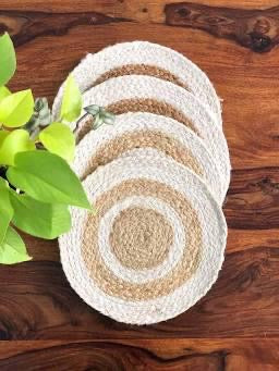 Round jute placemats set of four in white and beige, hand-braided natural fiber table mats stacked on wood table